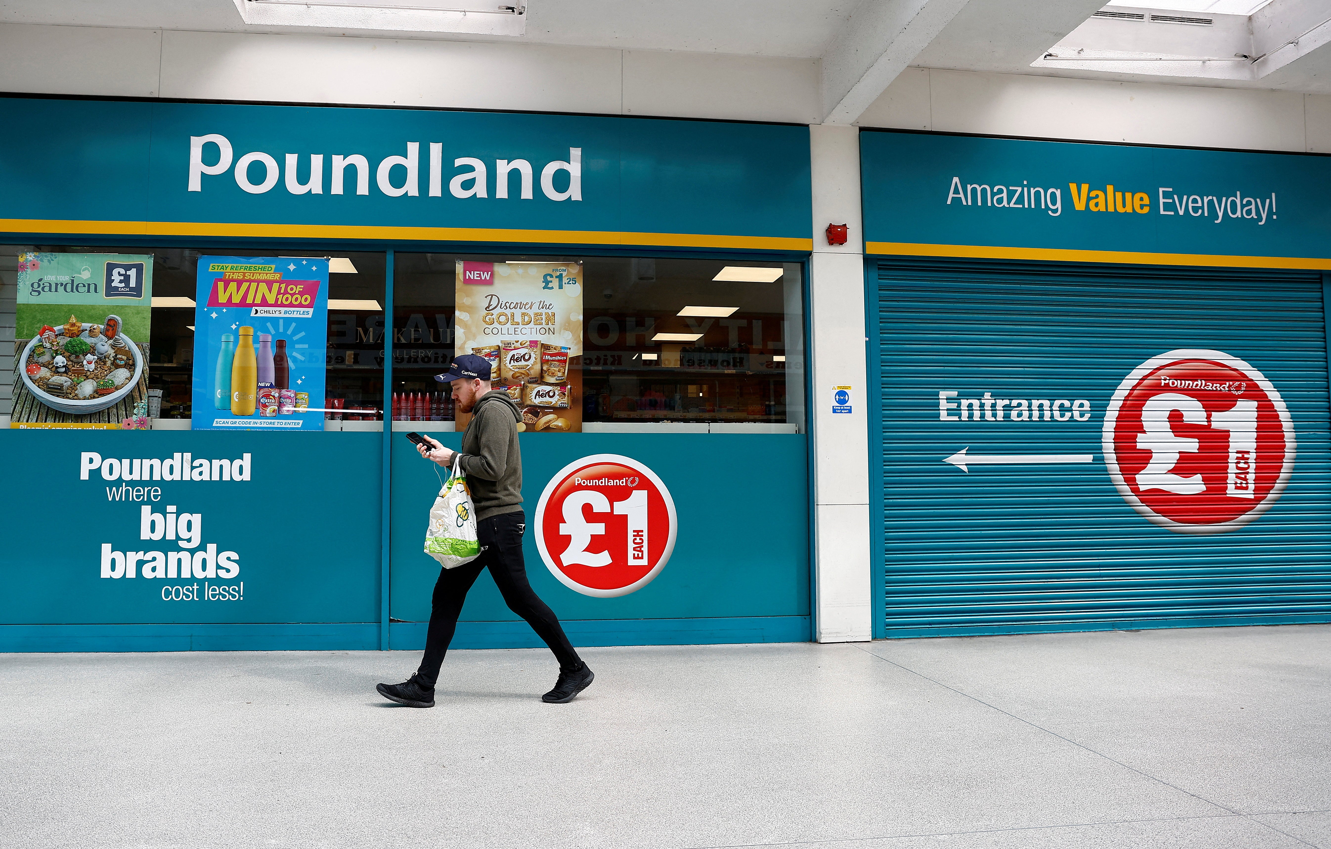 A man walks past a Poundland store in London